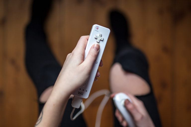 A person holding a wii video game controller.