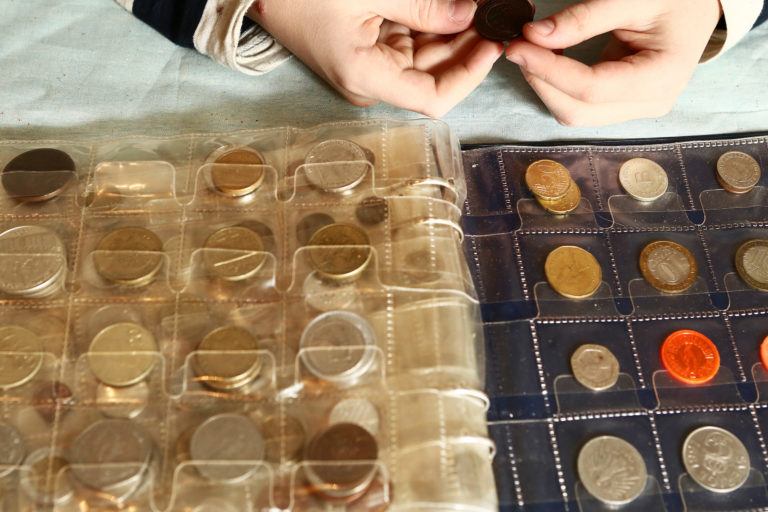 A person examining a collectible coin collection.