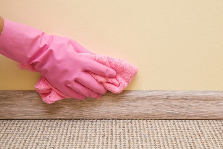 A gloved hand wiping down a wall.