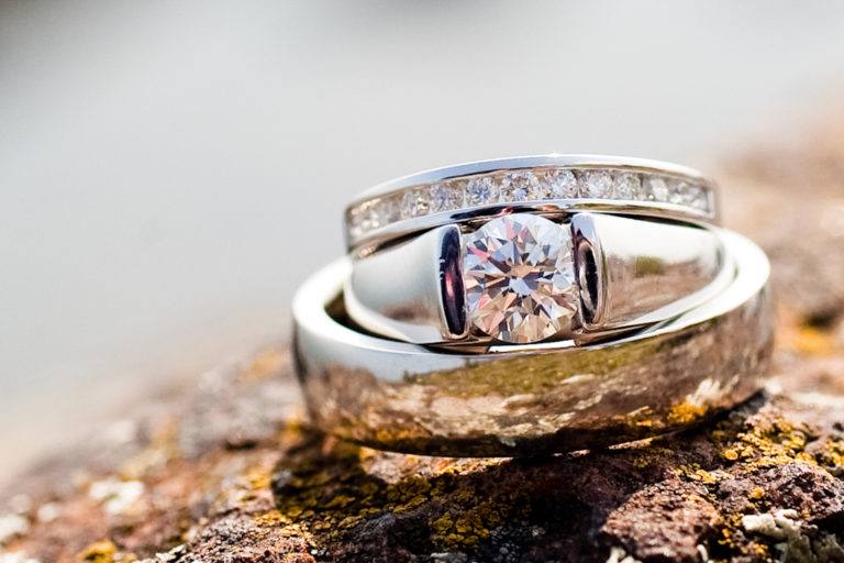 White gold wedding rings stacked on a rock.